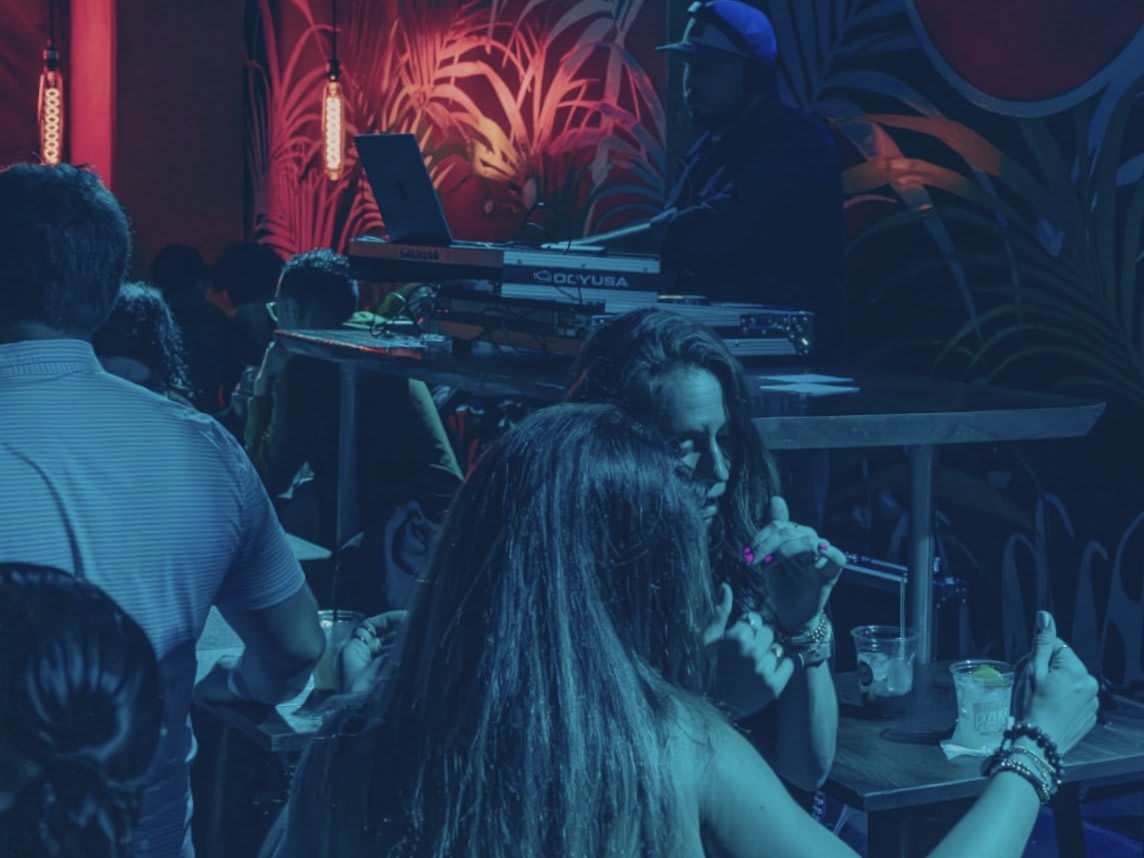 A lively nightclub scene with people dancing, a DJ playing music, and colorful lighting in Atlanta, Georgia.