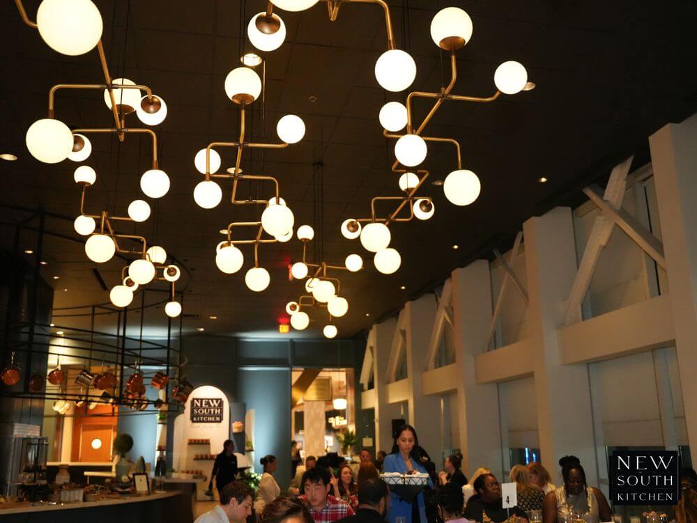 A modern restaurant with a high ceiling, featuring a unique chandelier and a bustling dining area in Atlanta, Georgia.