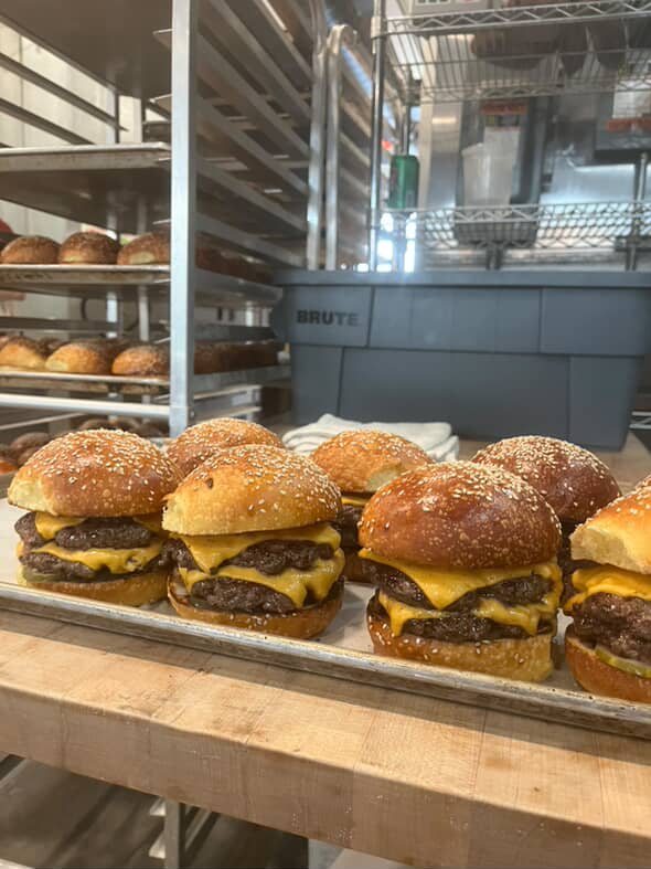 Ultimate Guide to Atlanta’s Pop-Up Restaurants and Supper Clubs 5 A tray of six double cheeseburgers with sesame seed buns in a bakery kitchen in Atlanta, Georgia.
