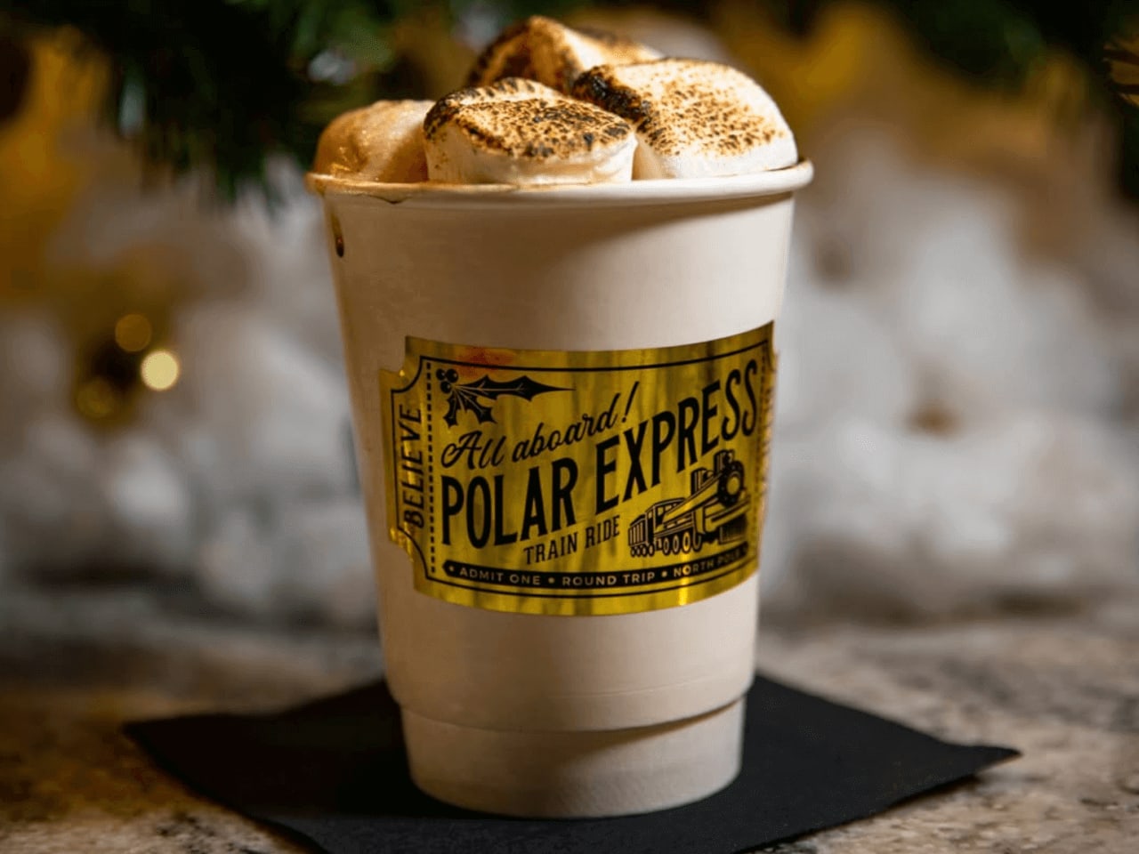 A festive cup of hot chocolate topped with marshmallows sits on a black napkin in Atlanta, Georgia.