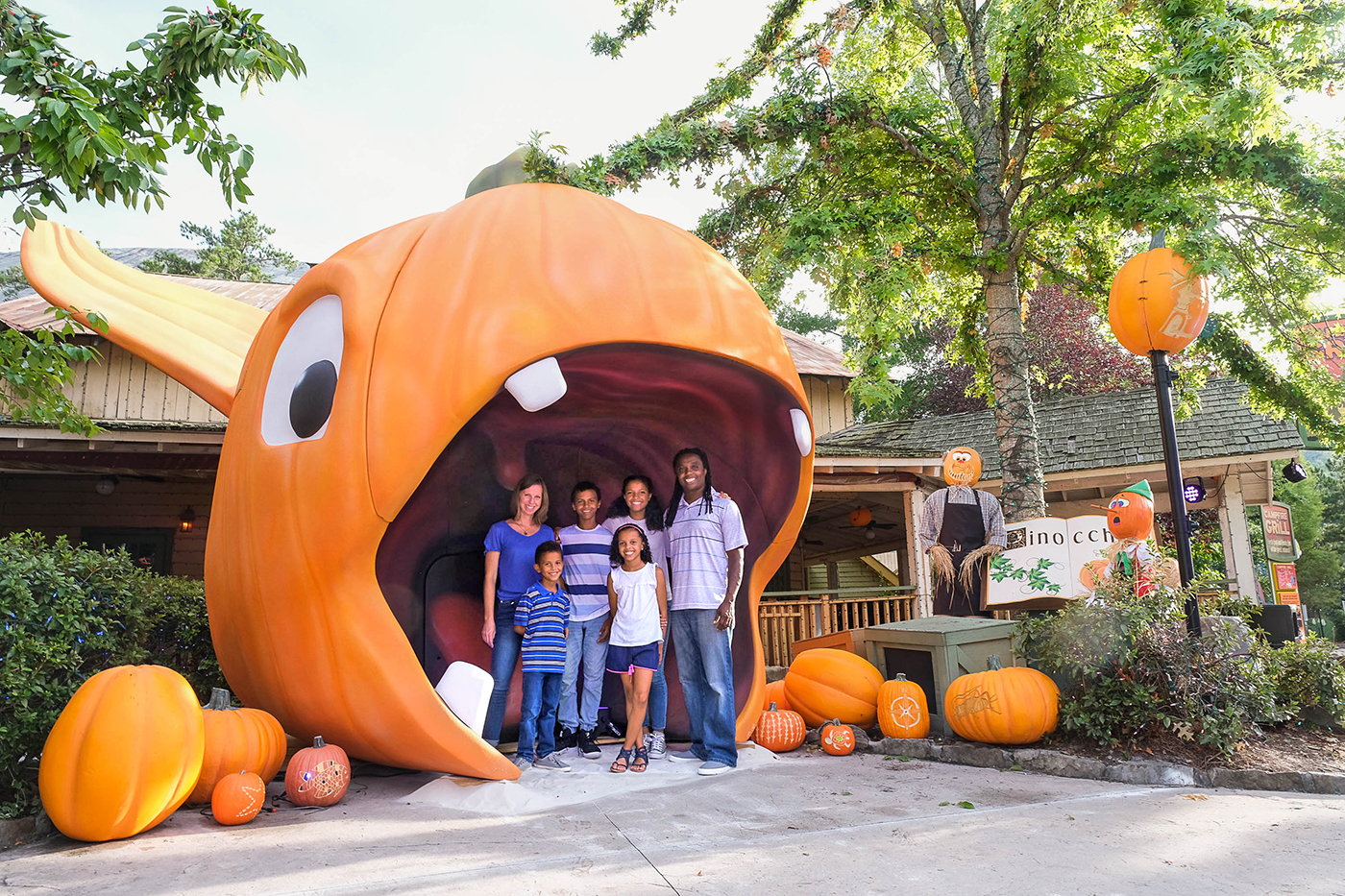 A family taking a picture in front of a large pumpkin head at Pumpkin Fest in Atlanta.