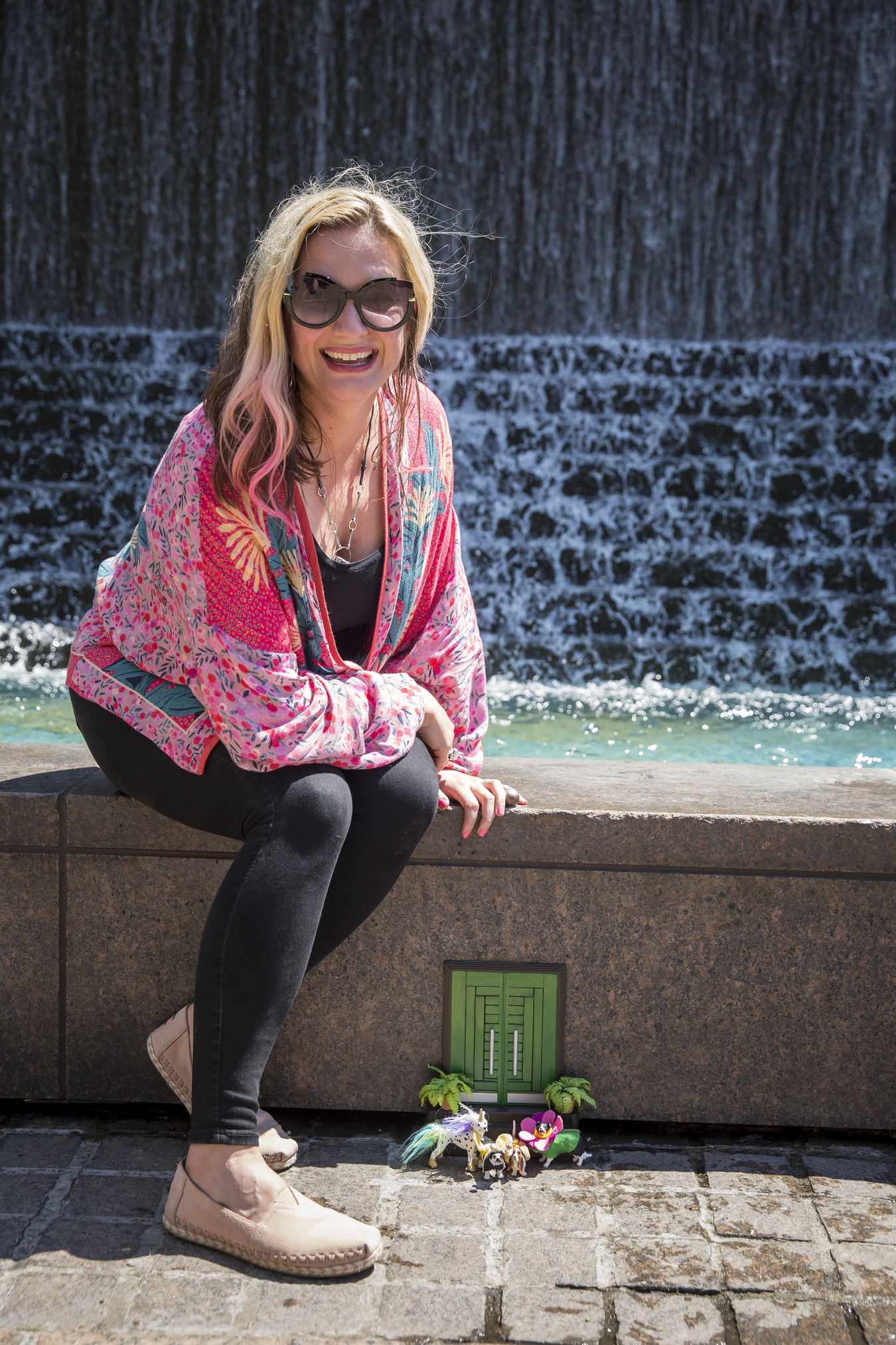 A woman smiling in front of a green tiny door in Atlanta.