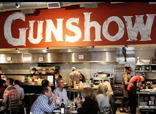 Where to Dine with a Large Group at Atlanta’s Michelin Guide Restaurants 11 A bustling restaurant kitchen with a large 'Gunshow' sign above in Atlanta, Georgia.