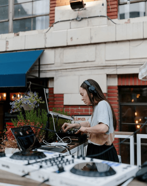 Woman DJ playing outdoors.