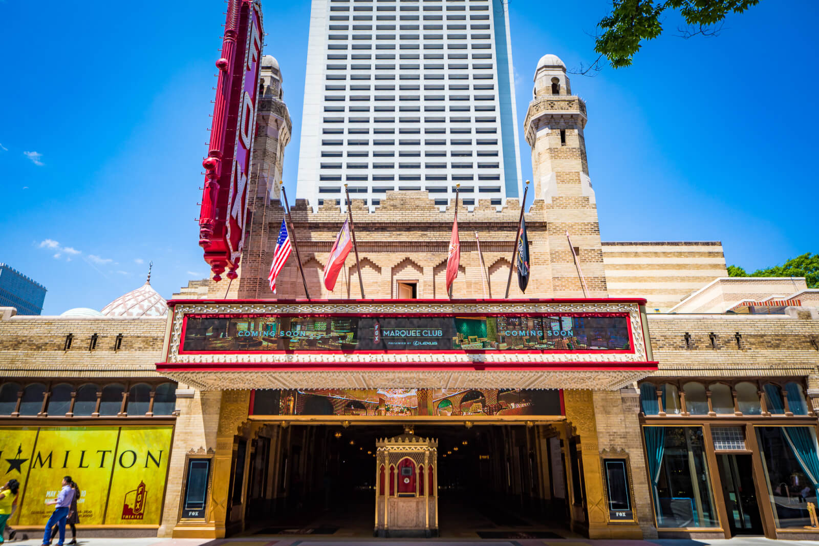 A grand theater with a large marquee and flags, featuring a show called 'Hamilton' in Atlanta, Georgia.