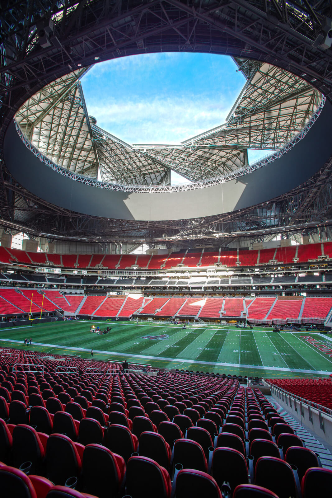 Everything You Need To Know About Mercedes-Benz Stadium in Atlanta 2 A modern stadium with a distinctive curved roof and red seating, ready for a sporting event in Atlanta, Georgia.