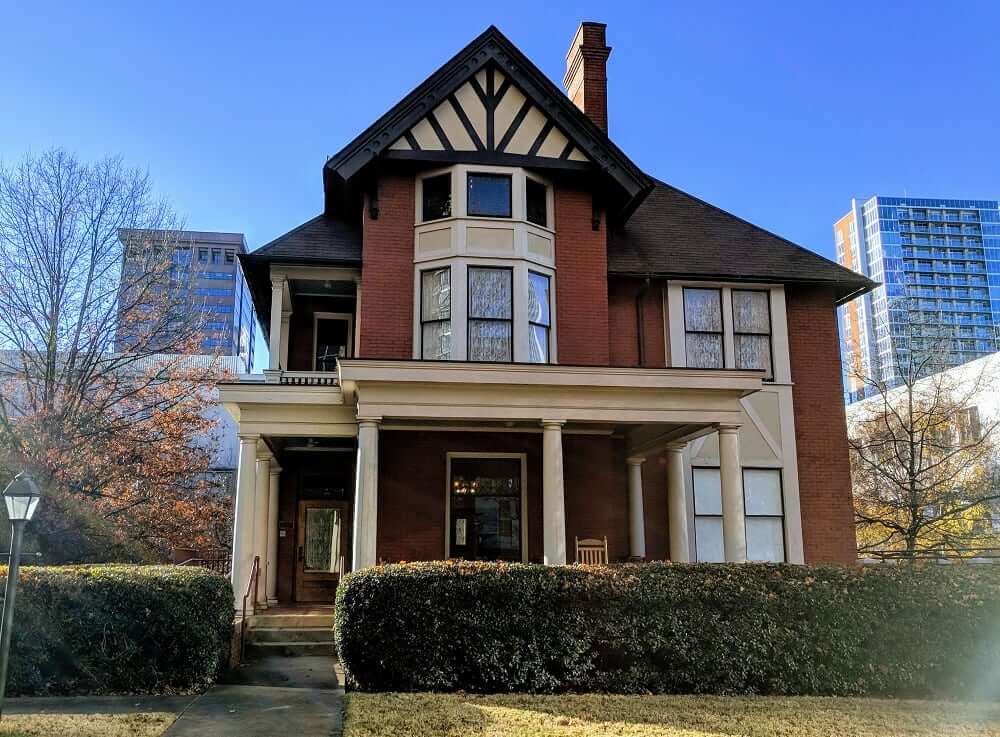 A two-story brick house with a gabled roof and a porch supported by columns in Atlanta, Georgia.