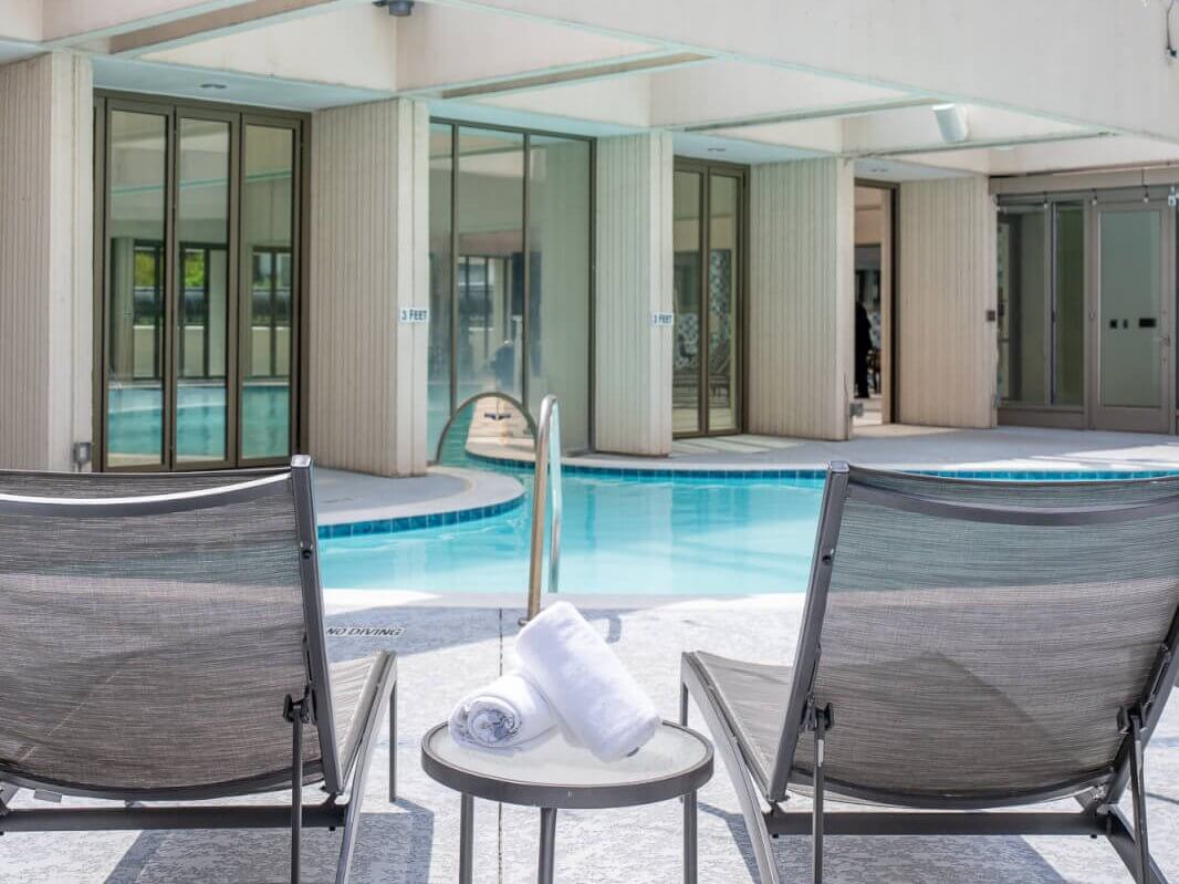 A serene rooftop pool area with lounge chairs and a city skyline backdrop in Atlanta, Georgia.