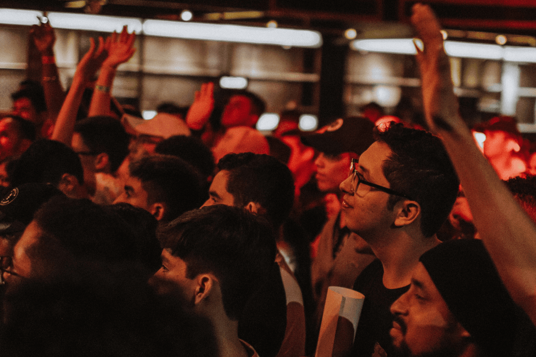 A lively crowd at a concert, with many people raising their hands in excitement in Atlanta, Georgia.