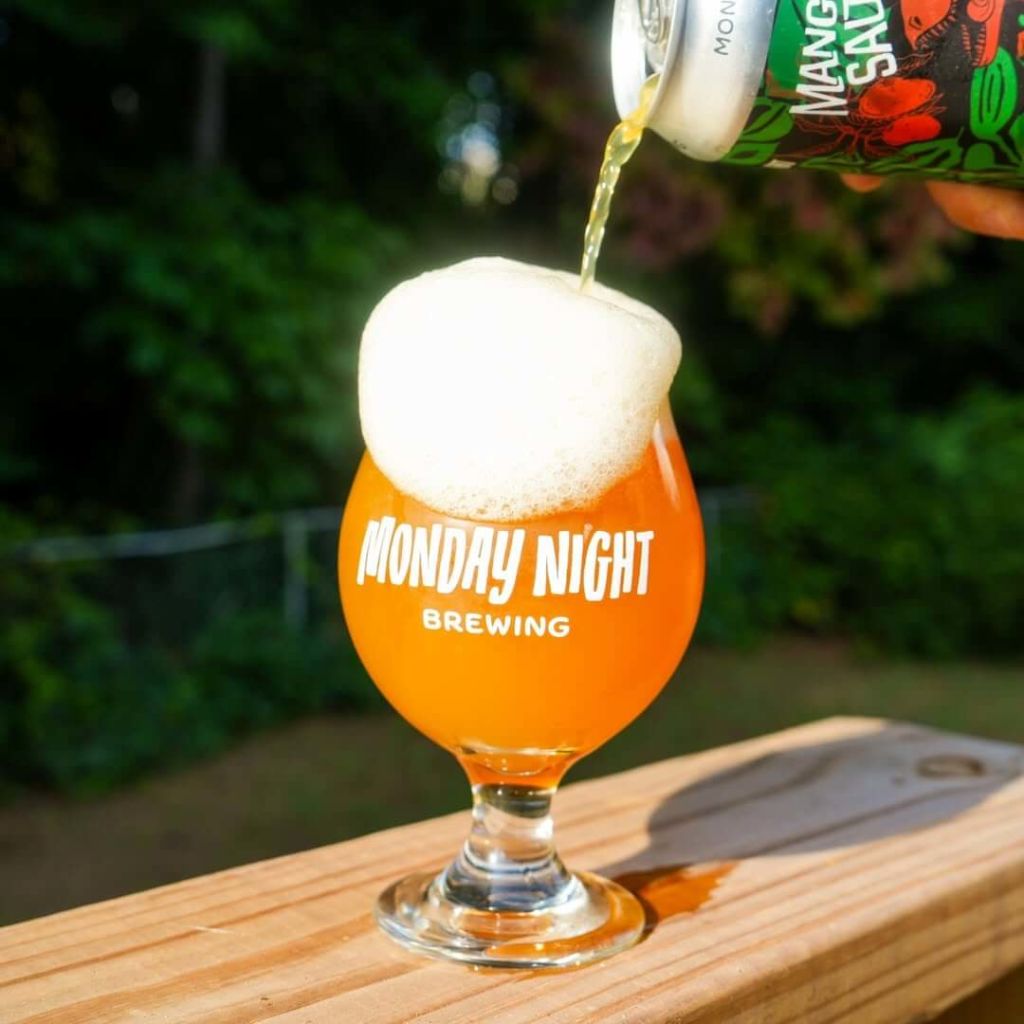 Where to Watch College Football in Atlanta 4 A can of Monday Night Brewing's Mango Salt beer is being poured into a branded glass, creating a frothy head in Atlanta, Georgia.