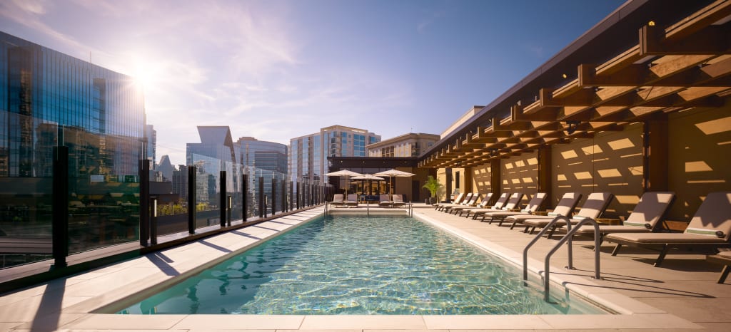 A rooftop infinity pool with lounge chairs, umbrellas, and a city skyline backdrop in Atlanta, Georgia.