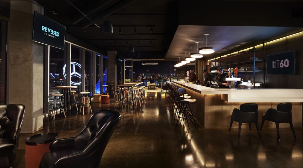 A modern, dimly lit bar with leather seating, a long counter, and neon signs in Atlanta, Georgia.