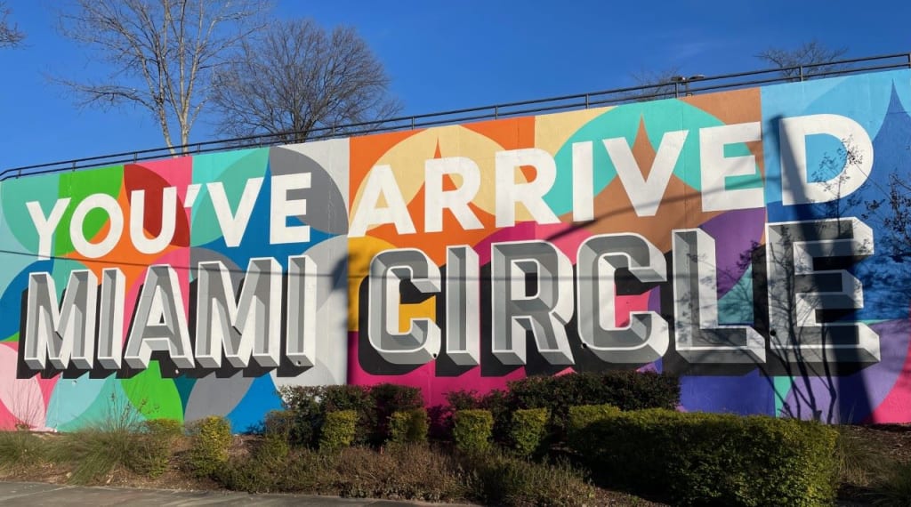 A vibrant mural welcomes visitors to Miami Circle with colorful geometric shapes and bold text in Atlanta, Georgia.