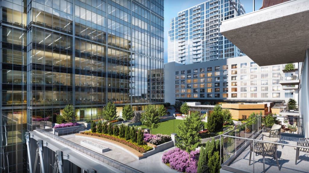 Modern urban courtyard with glass-walled buildings, green spaces, and seating areas in Atlanta, Georgia.