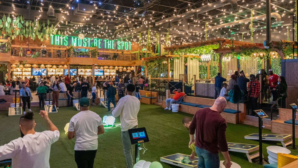 A lively indoor venue with a jungle theme, featuring a bar, games, and a crowd of people in Atlanta, Georgia.