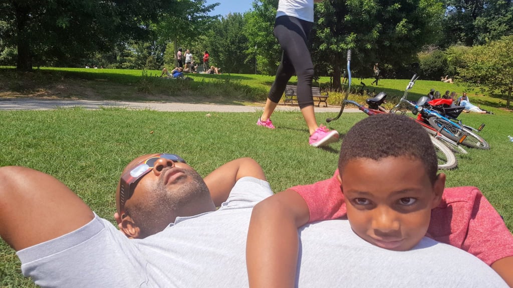 Outdoor Family Fun in Atlanta and Beyond 8 a man and child lying on grass at Piedmont park