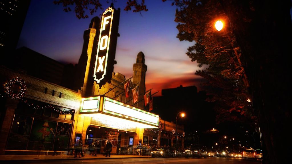 The Fox Theatre's illuminated marquee and neon sign glow against a twilight sky in Atlanta, Georgia.