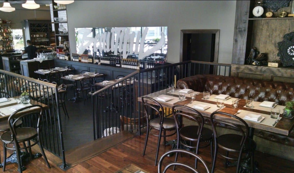 A stylish restaurant interior with leather booths, wooden tables, and a modern bar area in Atlanta, Georgia.