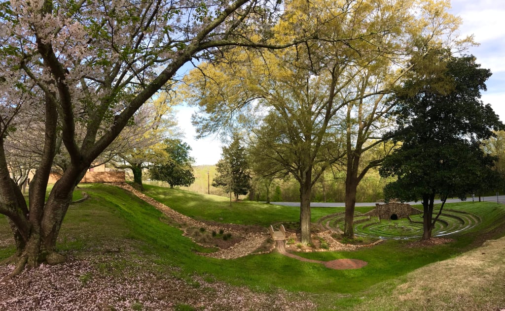 Nearby Day Trips 7 A serene park scene with a winding path, cherry blossoms, and a stone labyrinth in Atlanta, Georgia.