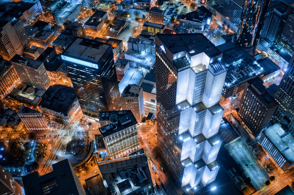 Aerial view of a bustling cityscape at night, showcasing illuminated skyscrapers and urban infrastructure in Atlanta, Georgia.