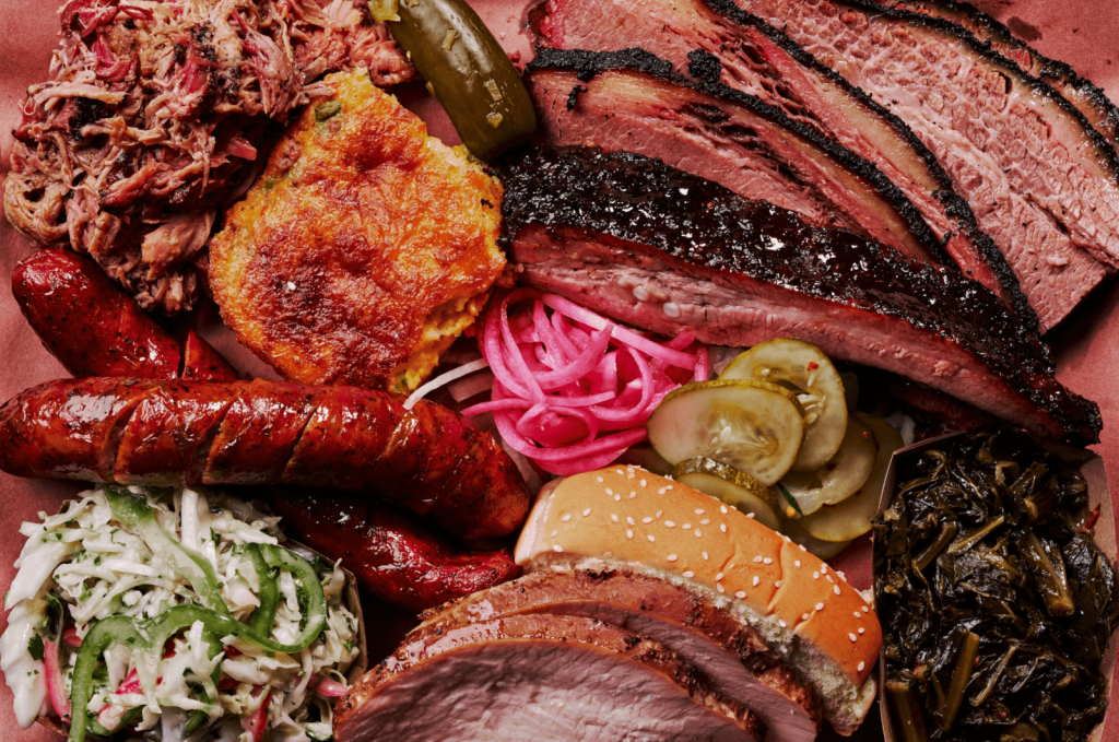 A mouthwatering barbecue platter featuring a variety of smoked meats, including pulled pork, brisket, and sausage, accompanied by classic sides like coleslaw, baked beans, and pickles in Atlanta, Georgia.