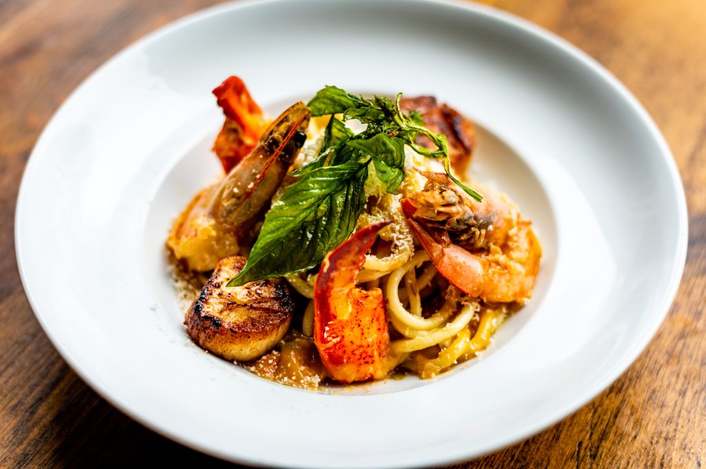 picture of bucatini with lobster, prawns, scallops and seafood brodo with fried basil from Twisted Soul Cookhouse & Pours in atlanta ga