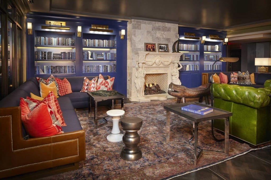 A luxurious living room with a fireplace, leather couches, and a large bookcase in Atlanta, Georgia.