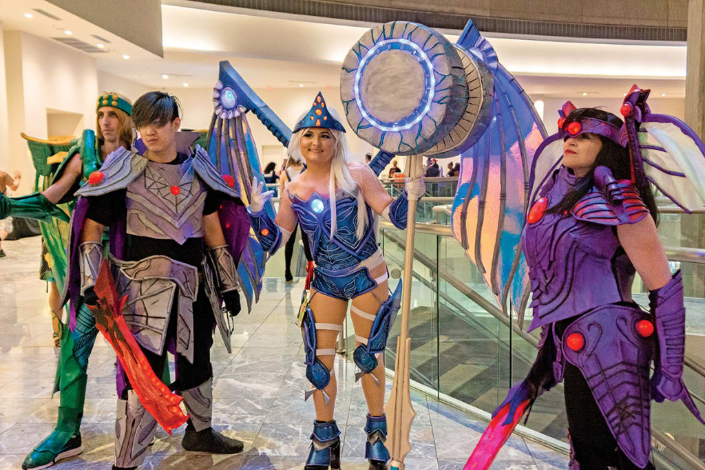 Four cosplayers dressed as fantasy characters with elaborate armor and weapons at a convention in Atlanta, Georgia.