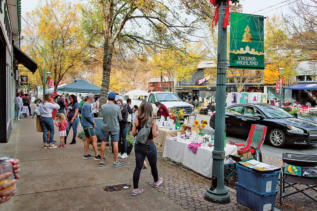 A bustling outdoor market with vendors, shoppers, and autumn foliage in Atlanta, Georgia.