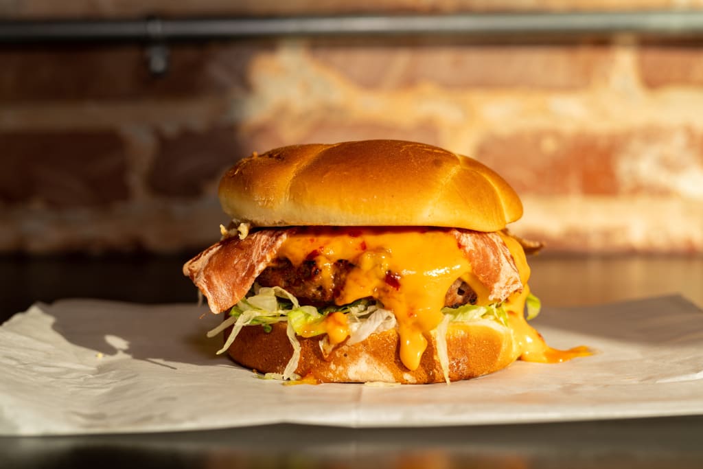 A mouthwatering cheeseburger with bacon, lettuce, and melted cheese on a toasted bun in Atlanta, Georgia.