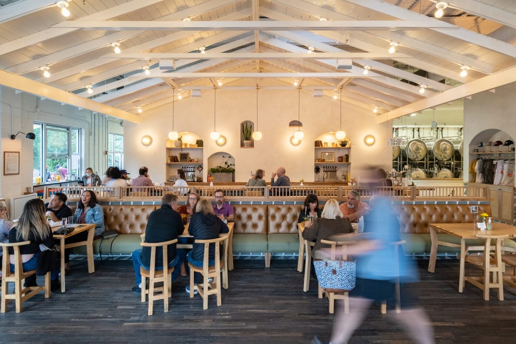 A spacious, modern restaurant with high ceilings, wooden beams, and a mix of booth and table seating in Atlanta, Georgia.
