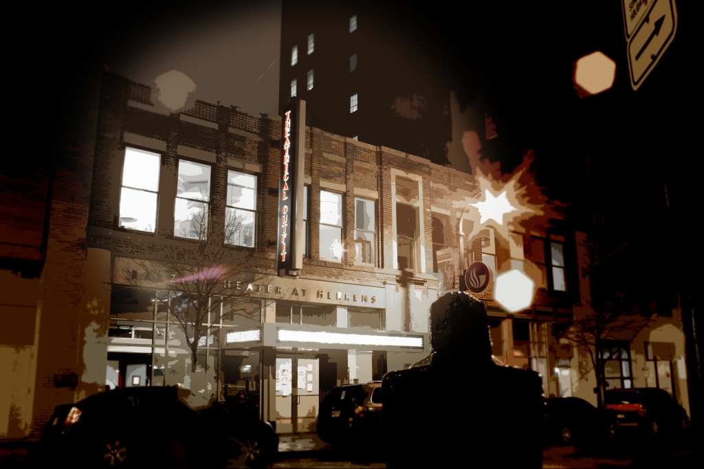 A nighttime view of a vintage theater with a marquee, surrounded by parked cars and street signs in Atlanta, Georgia.