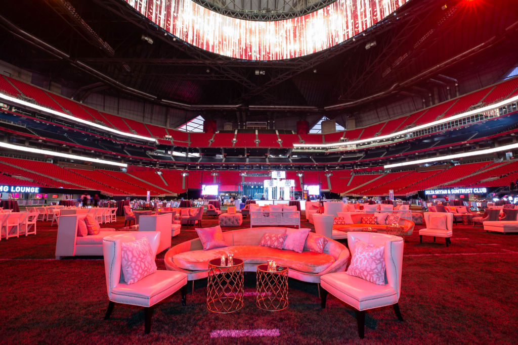 A large indoor stadium transformed into a luxurious lounge with plush seating and decorative lighting in Atlanta, Georgia.
