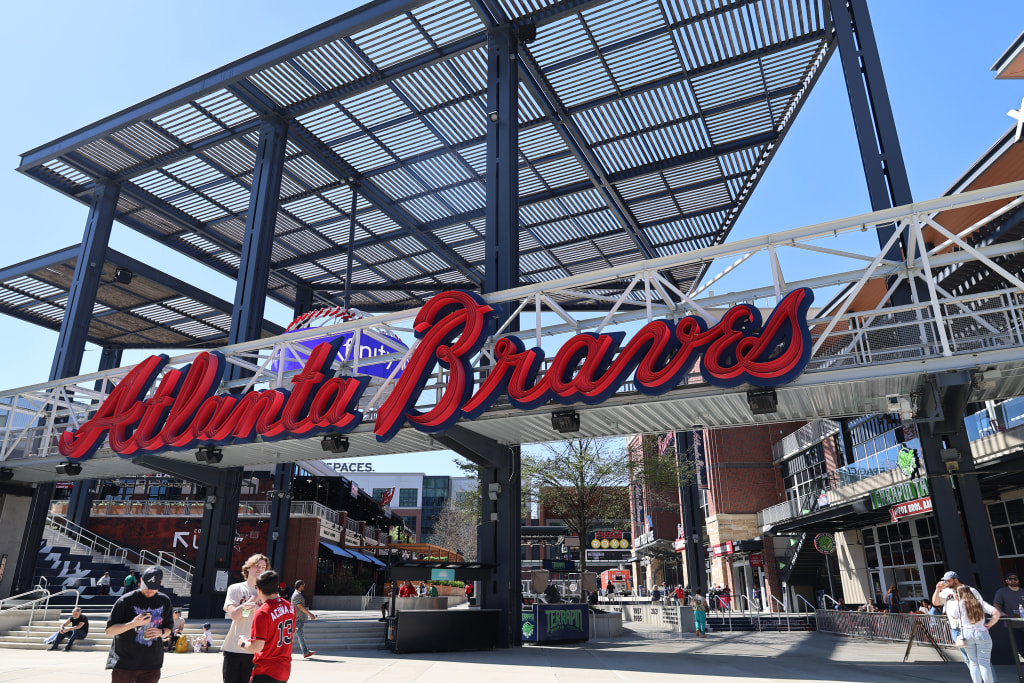 A bustling stadium entrance with a large 'Atlanta Braves' sign and fans entering in Atlanta, Georgia.