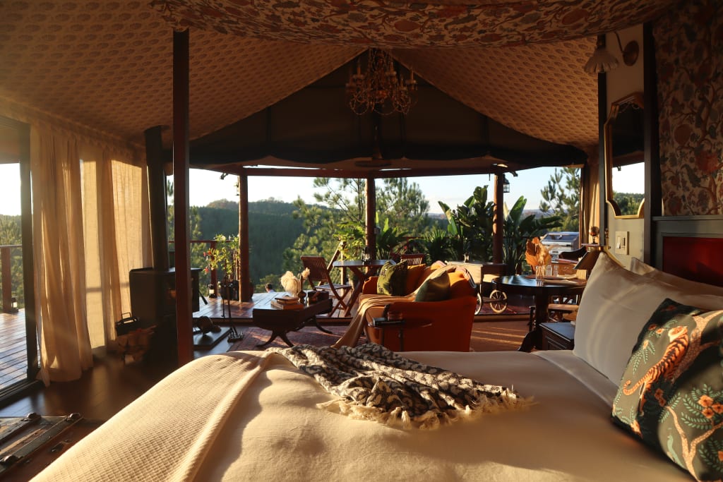 Luxurious tented room with a view, featuring a bed, seating area, and outdoor deck in Atlanta, Georgia.