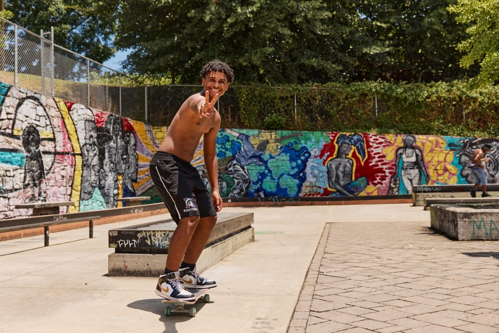 Explore Atlanta Beltline Southside Trail 2 A young man skateboards in a park with colorful graffiti murals on the walls in Atlanta, Georgia.