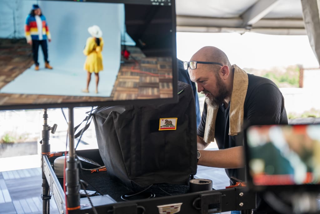 A bald man with a beard and glasses is working with audio equipment in a studio setting in Atlanta, Georgia.