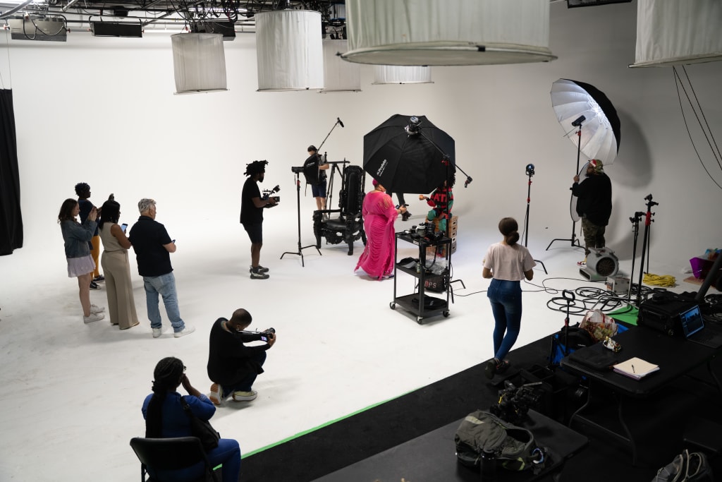 A diverse group of people in a professional photo studio with various lighting equipment in Atlanta, Georgia.