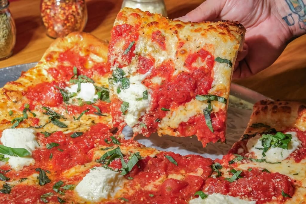 Virginia Highland 6 a hand holding a slice of pizza