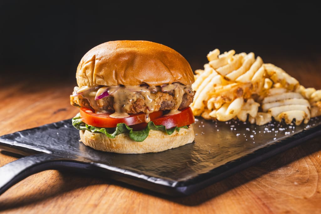 A mouthwatering cheeseburger with crispy fries on a rustic wooden table in Atlanta, Georgia.