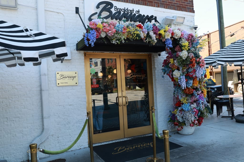 breakfast at barneys signage, gold door and florals