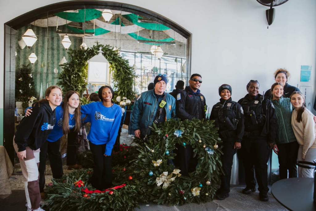 A diverse group of police officers and community members pose with Christmas wreaths in Atlanta, Georgia.