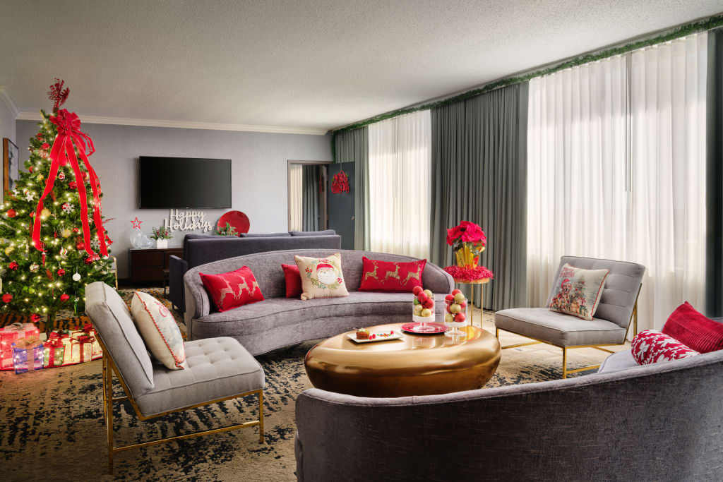 A festive living room with a Christmas tree, red and gold decor, and a curved sofa in Atlanta, Georgia.