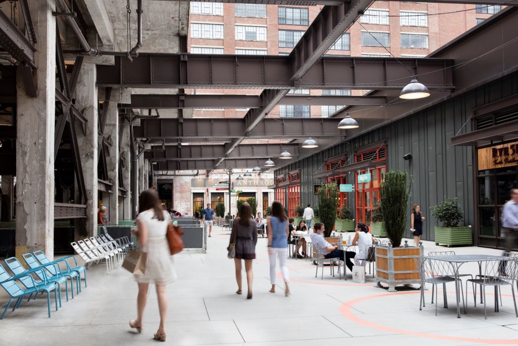 A bustling indoor market with exposed beams, potted plants, and people dining and walking in Atlanta, Georgia.