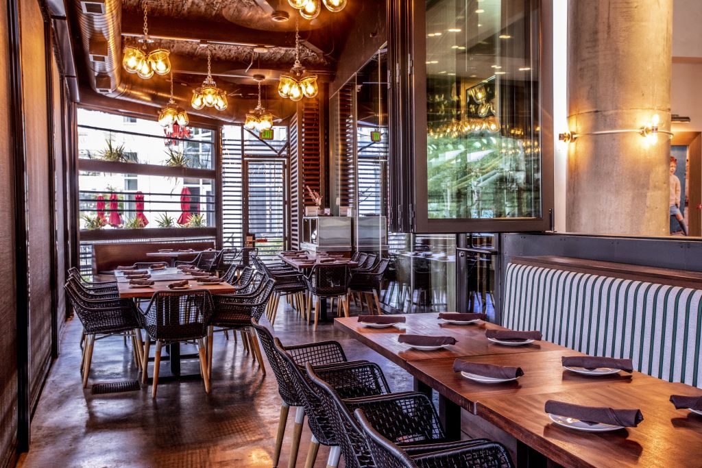 Tables and chairs in an indoor-outdoor patio. 