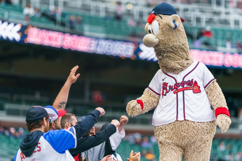 A large, furry Braves mascot greets fans in the stands during a baseball game in Atlanta, Georgia.