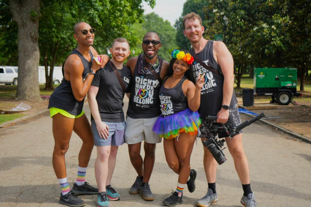 A group of six people, five men and one woman, are standing together outdoors, smiling and posing for a photo in Atlanta, Georgia.