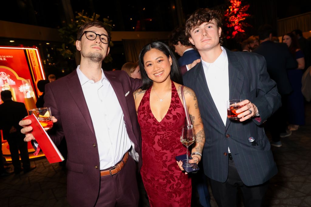 Three people in formal attire holding drinks at a social event in Atlanta, Georgia.