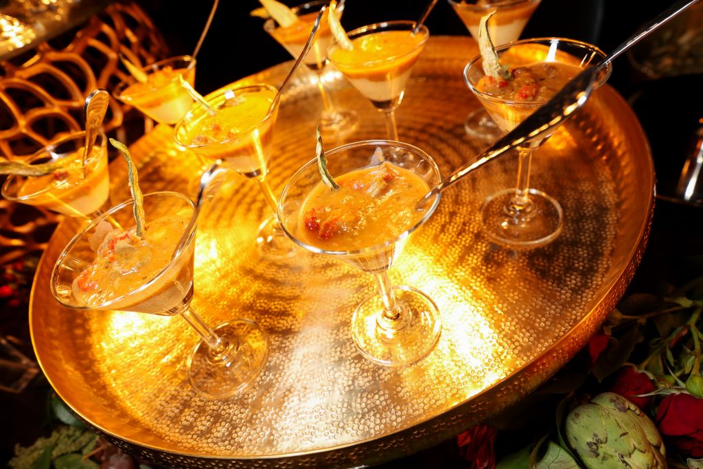 Golden martini glasses filled with colorful layered desserts on a reflective tray in Atlanta, Georgia.
