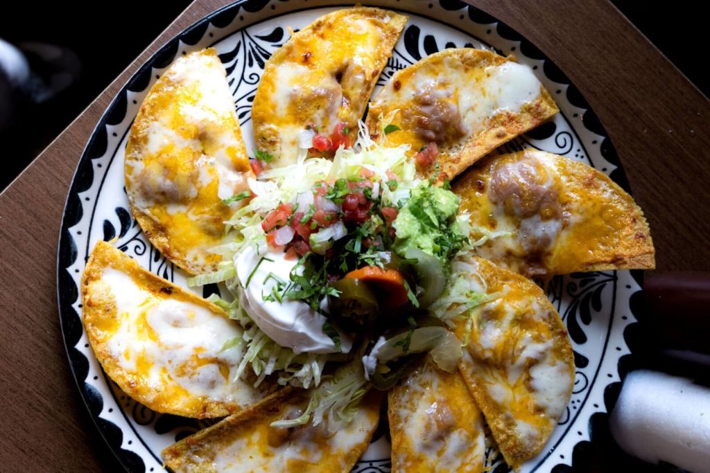 A colorful plate of loaded nachos with melted cheese, fresh salsa, and sour cream in Atlanta, Georgia.